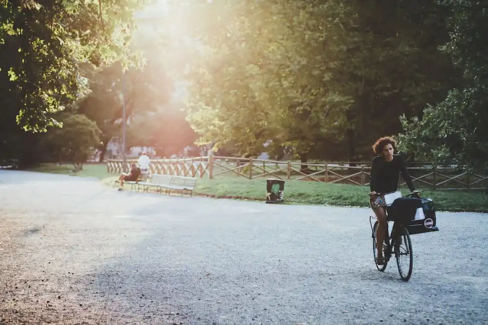 Woman riding a bike in a park after meth rehab